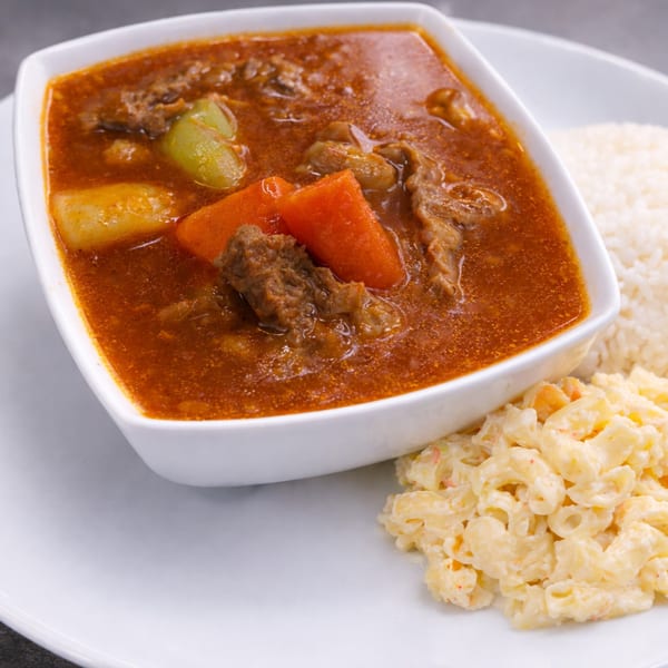 Beef stew with carrots, potatoes, and celery, served with white rice and macaroni salad.
