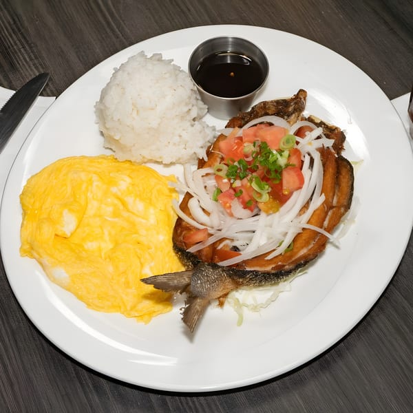 Fried fish with tomato, onion, and scallion topping, served with rice, scrambled eggs, and sauce.