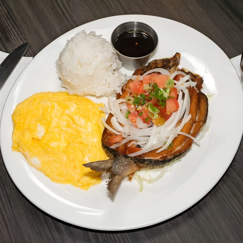 Fried fish with tomato, onion, and scallion topping, served with rice, scrambled eggs, and sauce.